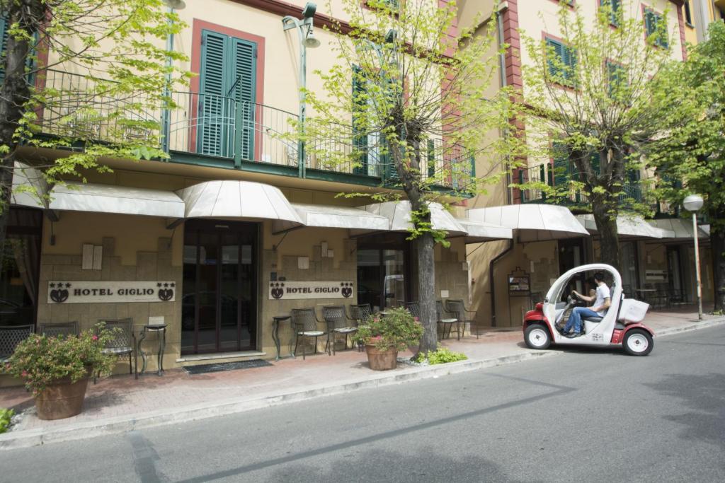 a scooter parked on a street in front of a building at Hotel Giglio in Montecatini Terme