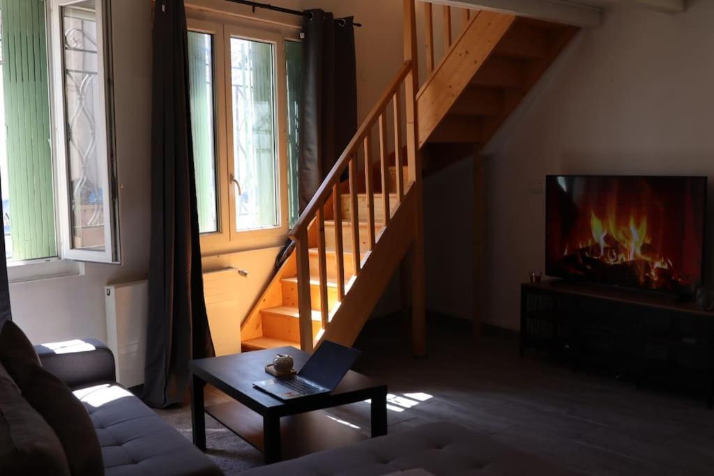 ein Wohnzimmer mit einer Treppe und einem Laptop auf einem Couchtisch in der Unterkunft Pavillon en loft 87 M 10e, jacuzzi in Marseille