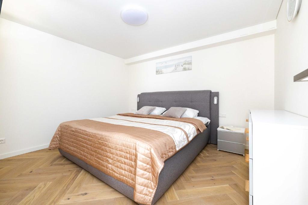 a bedroom with a large bed in a white room at New Apt w/Terrace, By Cohost in Palanga
