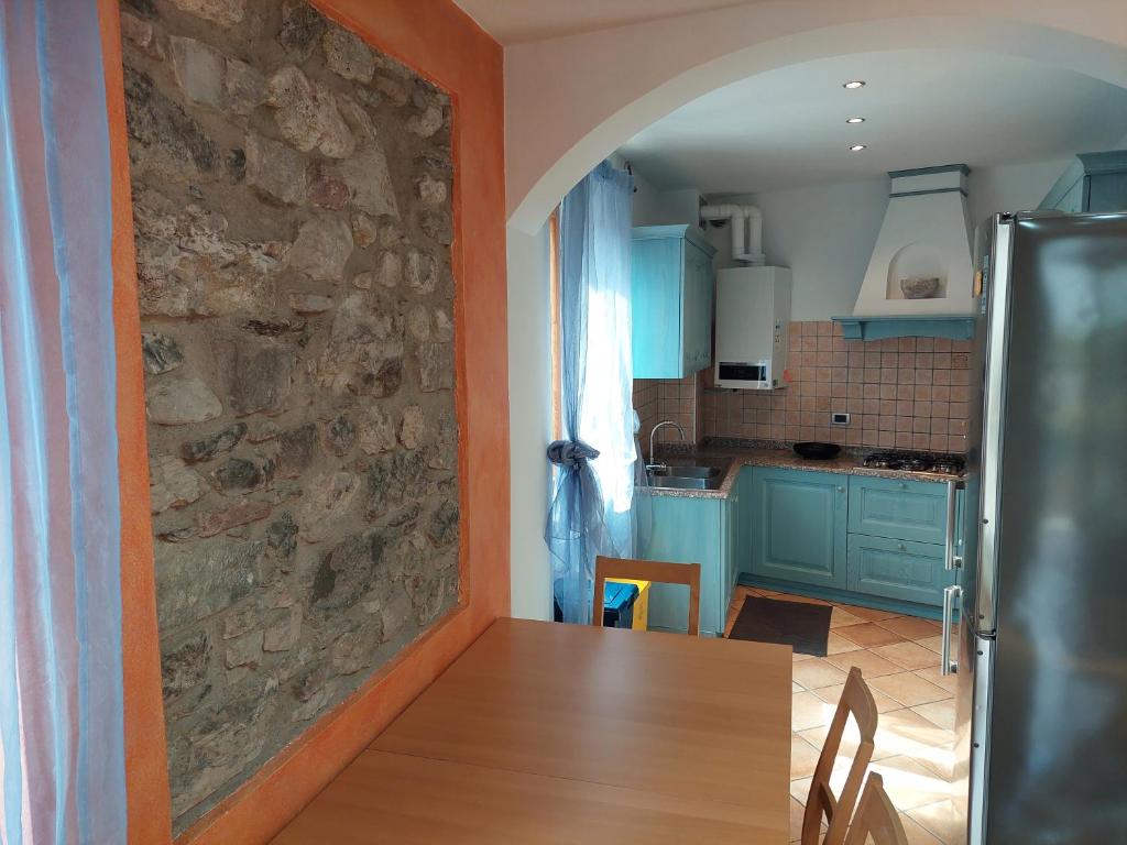 una cocina con una pared de piedra junto a una mesa en Appartamento Borgo Centro, en Borgo