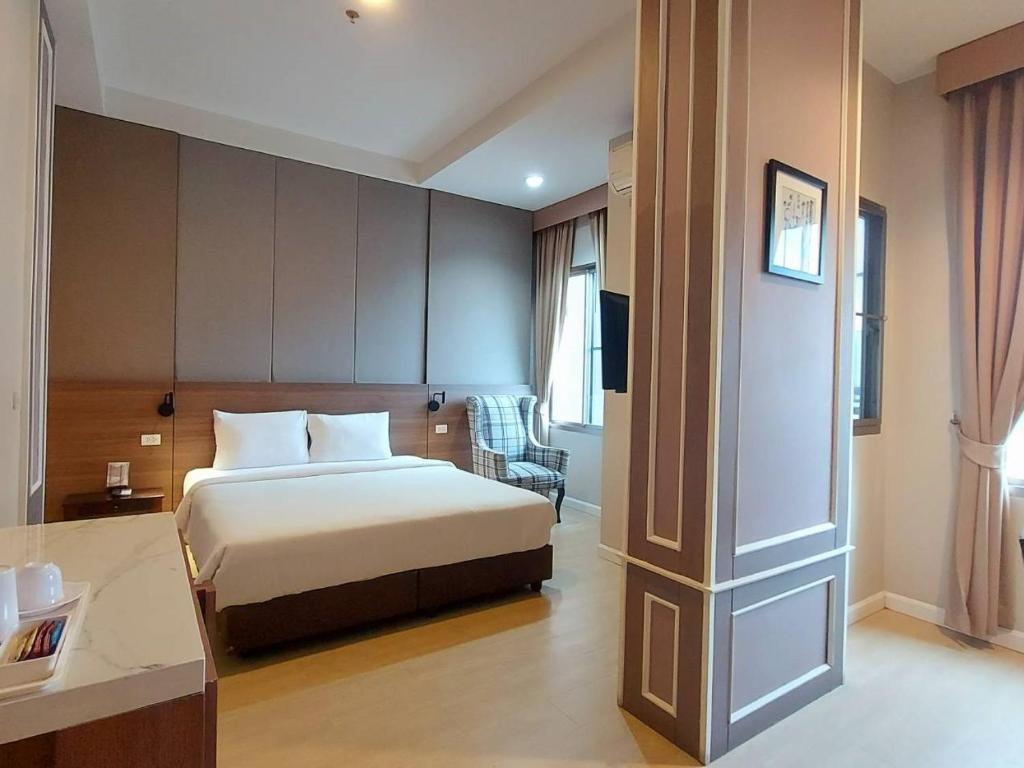a hotel room with a bed and a desk at J Park Hotel - SHA Extra Plus in Chon Buri