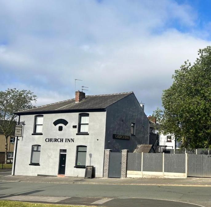 a black and white building with a sign on it at Church inn en-suite rooms with Wi-Fi in Moorside