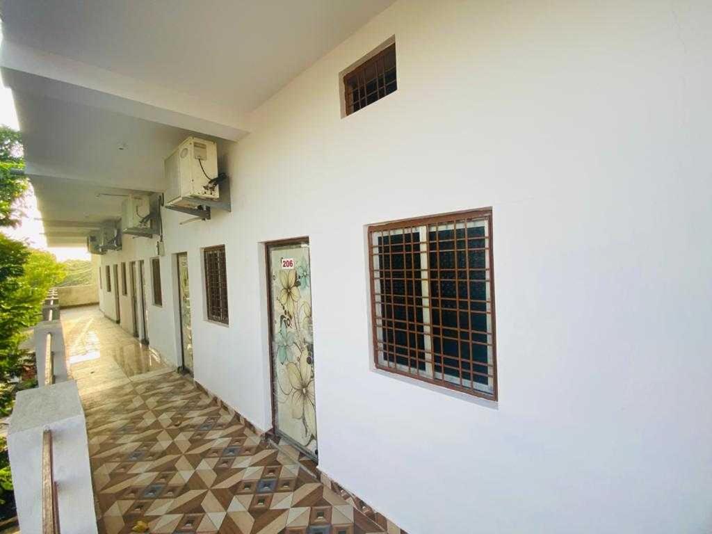 een hal van een wit gebouw met een raam bij OYO Hotel Daisy in Jabalpur