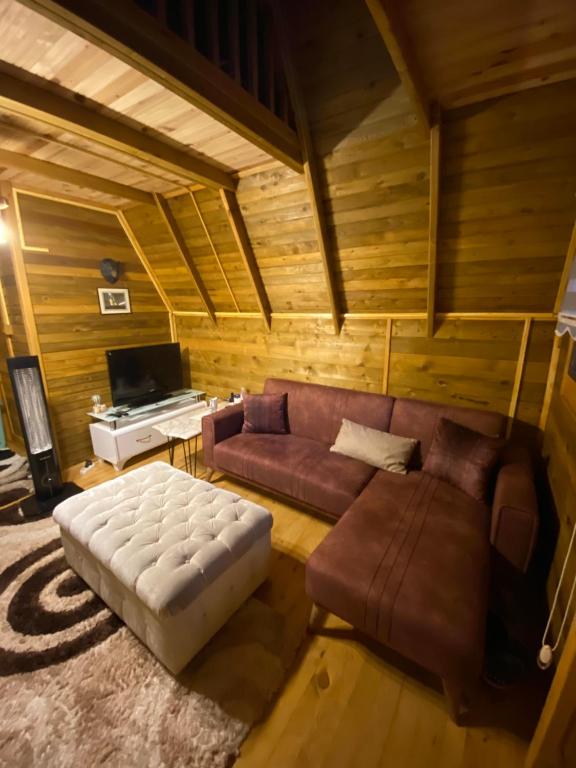 ein Wohnzimmer mit einem Sofa und einem Tisch in der Unterkunft Şehre yakın doğa içinde Bungalov 