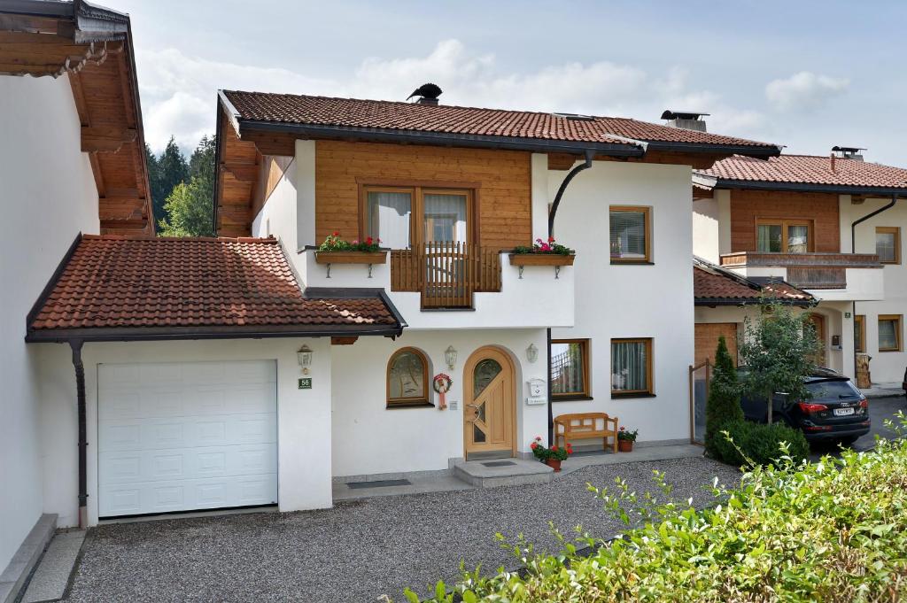 ein Haus mit einer Garage und einem Auto vor dem Haus in der Unterkunft Ferienhaus Siglinde in Söll