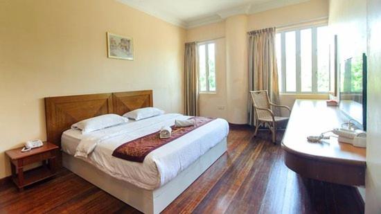 - une chambre avec un grand lit et un bureau dans l'établissement SC Hotel Melaka, à Malacca