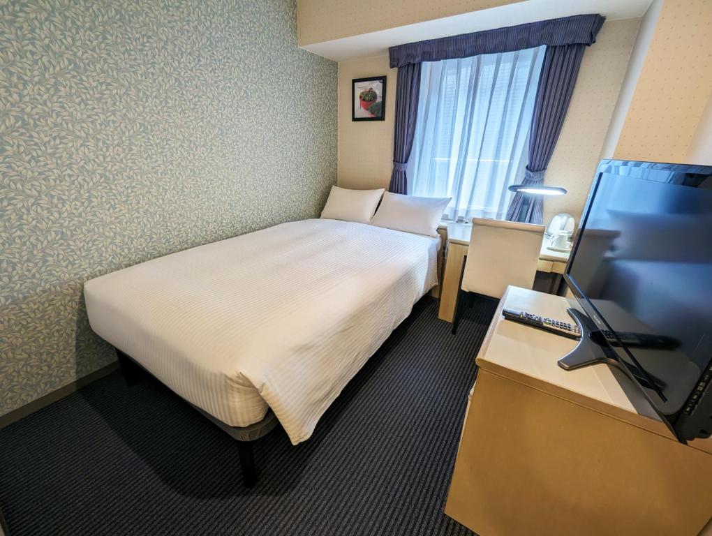 Postel nebo postele na pokoji v ubytování Shin-Yokohama Kokusai Hotel