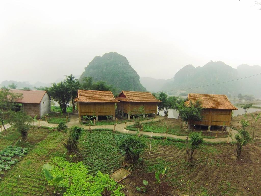 a group of houses with mountains in the background at Ham Rong Bungalow in Xuân Sơn