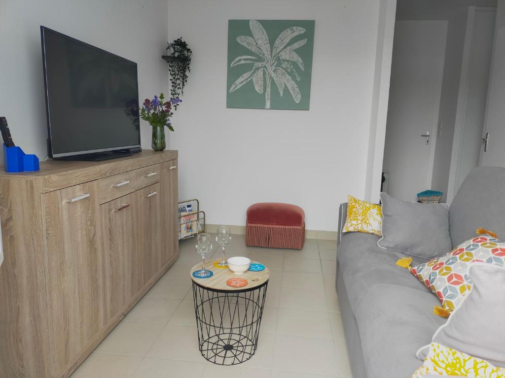 - un salon avec un canapé et une télévision dans l'établissement Maison au coeur de Saint-Gilles L'Inattendue, à Saint-Gilles-Croix-de-Vie