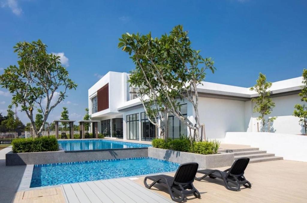 a house with a swimming pool and two chairs at EZHomestay Platinum near Cyberjaya Putrajaya KLIA in Kampung Dengkil