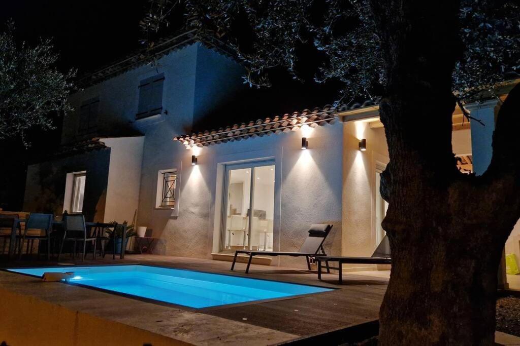 a swimming pool in front of a house at night at Nice, Magnifique villa vue mer avec piscine in Nice