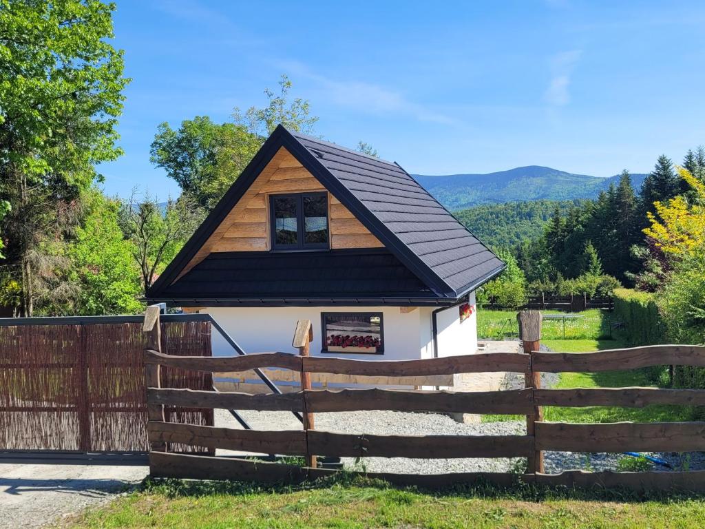 uma pequena casa com uma cerca em frente em Widokówka em Zawoja