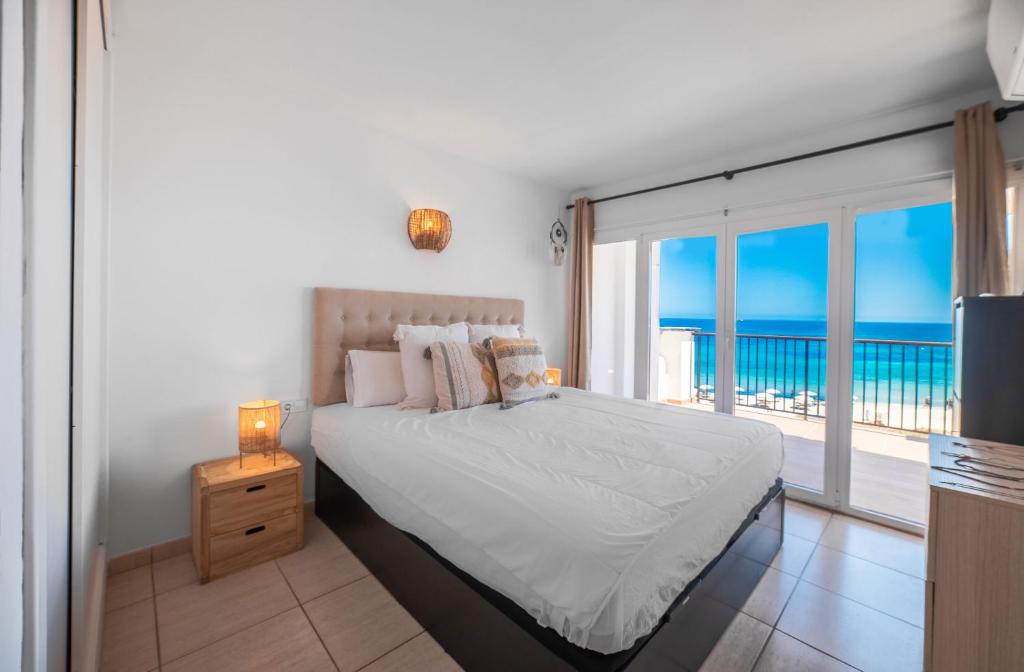 een slaapkamer met een bed en uitzicht op de oceaan bij Sea Front apartment in Ibiza-stad