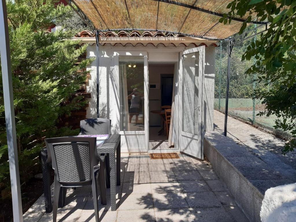 a patio with a table and chairs and a pergola at La ferme de Manon in Montferrat