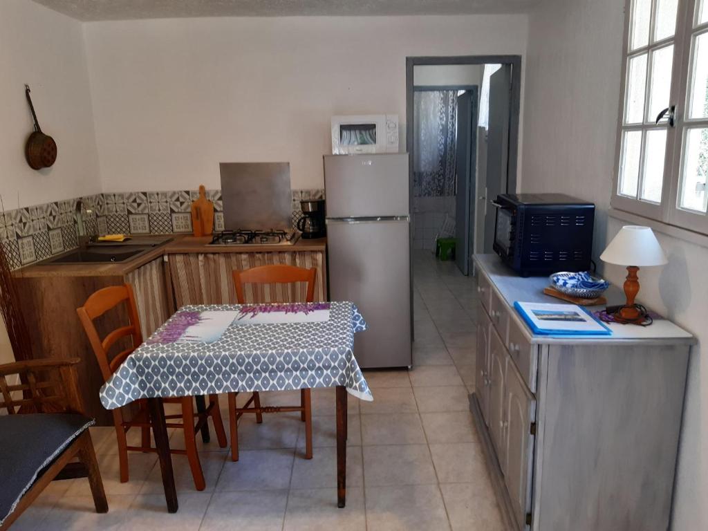 a kitchen with a table and a refrigerator at La ferme de Manon in Montferrat