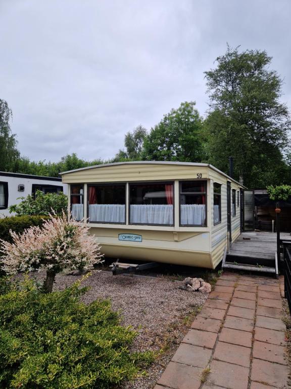 a small house is parked in a yard at Ruime 6 persoons Orlando Super in De Pol