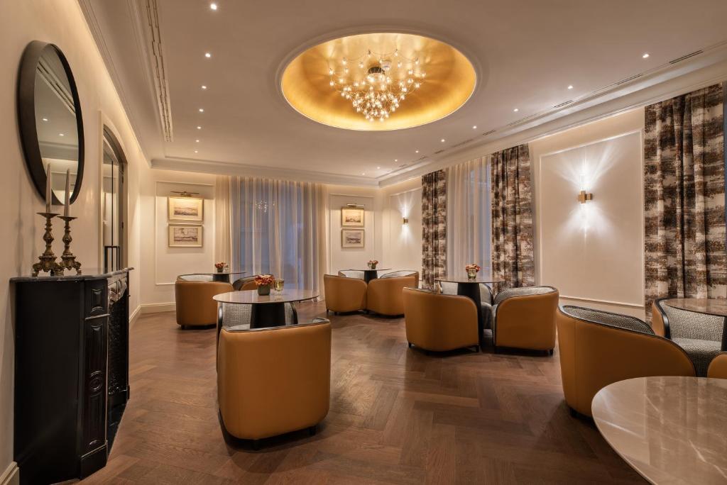 a hotel lobby with chairs and tables and a chandelier at Áurea Casa Palacio Sagasta by Eurostars Hotel Company in Cádiz