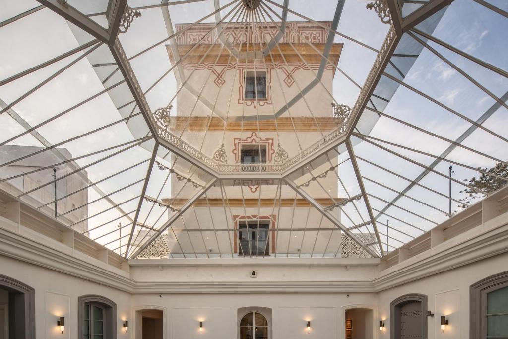 a glass ceiling in a room with a building at Áurea Casa Palacio Sagasta by Eurostars Hotel Company in Cádiz