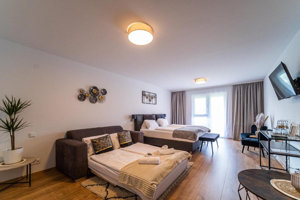 a living room with a couch and a bed at Hotel Fuchs & Hase SELF CHECK IN in Rosegg