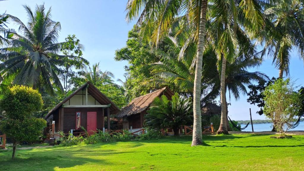 a house on the beach with palm trees at Bungalow in Karimunjawa