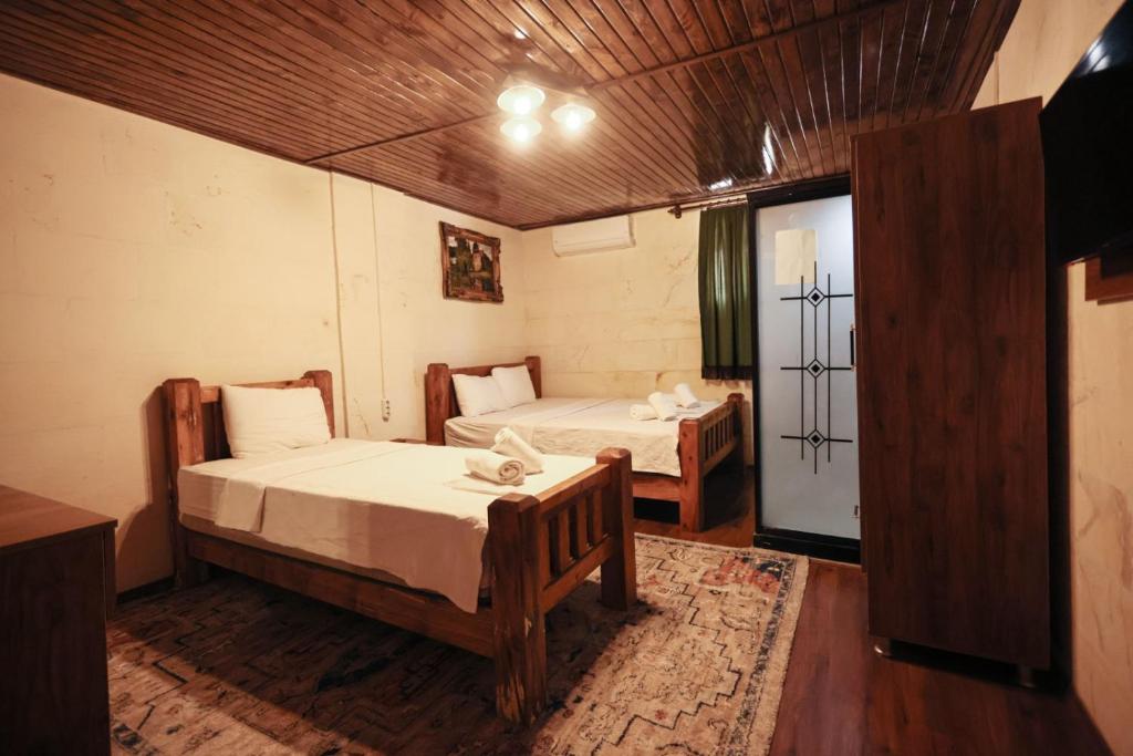 um quarto com duas camas e uma porta com uma janela em Osmanlı Konağı - Şerif Paşa Butik Otel em Şanlıurfa