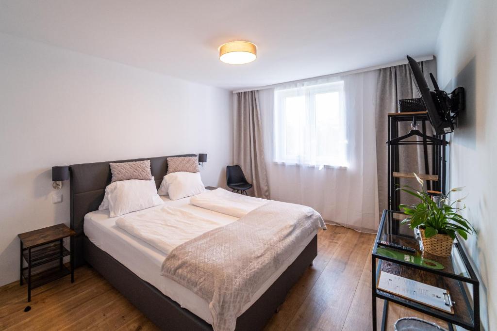 a bedroom with a large bed and a window at Hotel Fuchs & Hase SELF CHECK IN in Rosegg