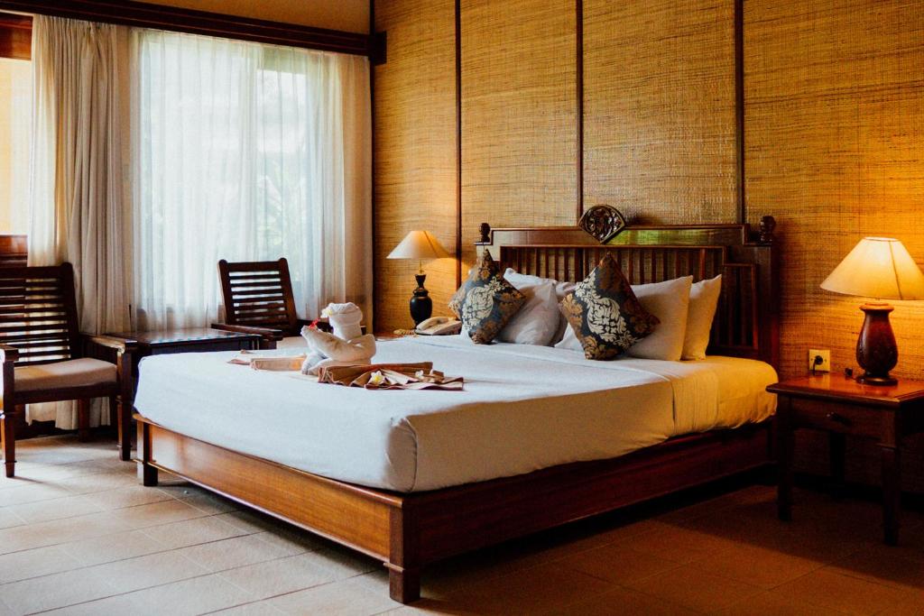 a bedroom with a bed with a teddy bear on it at Sri Phala Resort & Villa in Sanur