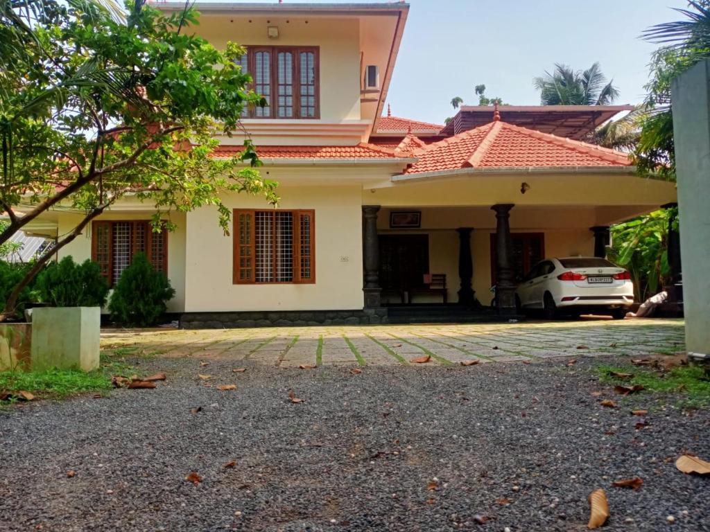 a house with a car parked in front of it at Sinai Homestay in Alleppey