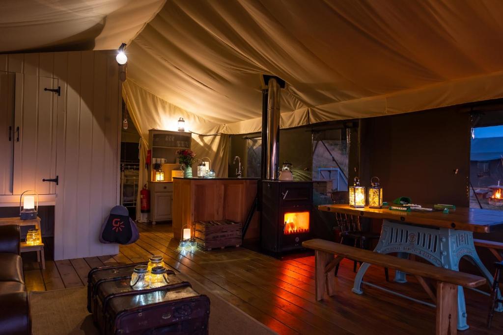 a living room with a tent with a fireplace at Canvas & Campfires in Lampeter