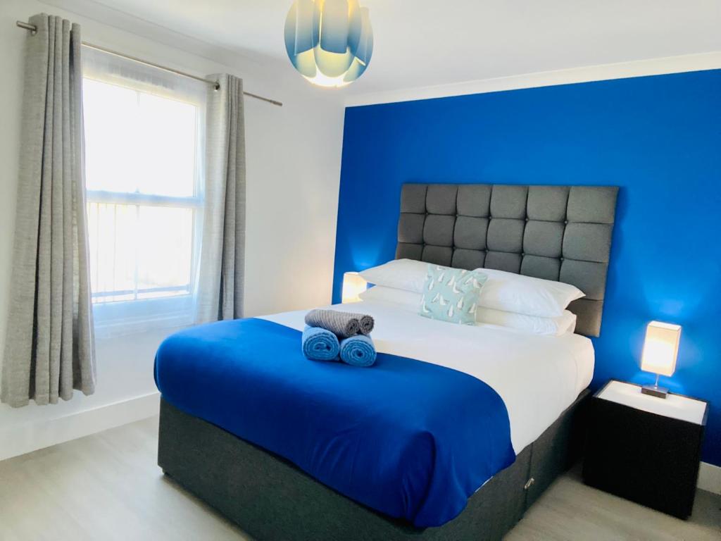 a blue bedroom with a bed with two teddy bears on it at Oceano - Carbis bay, St Ives, 1 bed apartment with free parking near to the beach in St Ives