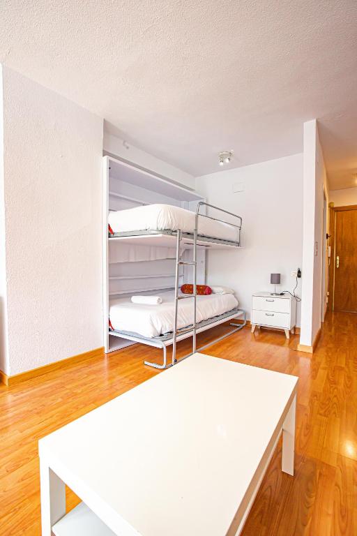 pokój z dwoma łóżkami piętrowymi i stołem w obiekcie Holidays, Mont Blanc Estudio en Pradollano & Parking w mieście Sierra Nevada