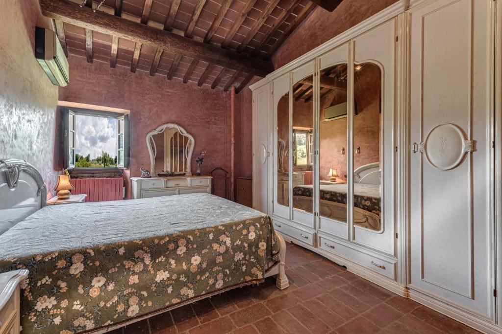 1 dormitorio con 1 cama grande y espejo en Il sopra, en Empoli
