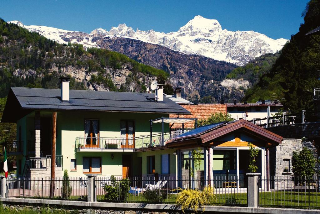 a house with snow covered mountains in the background at B&B La Beula in Baceno