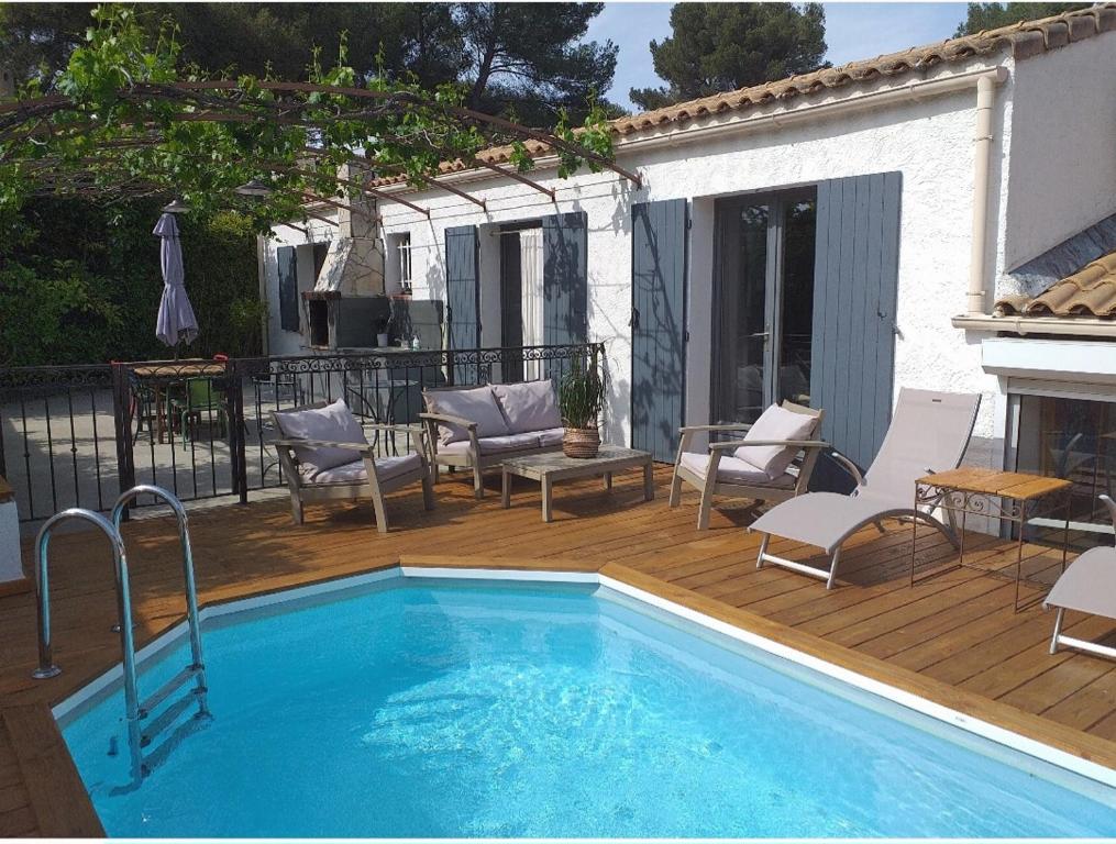 a pool on a deck with chairs and a table at Maison en Provence in Salon-de-Provence