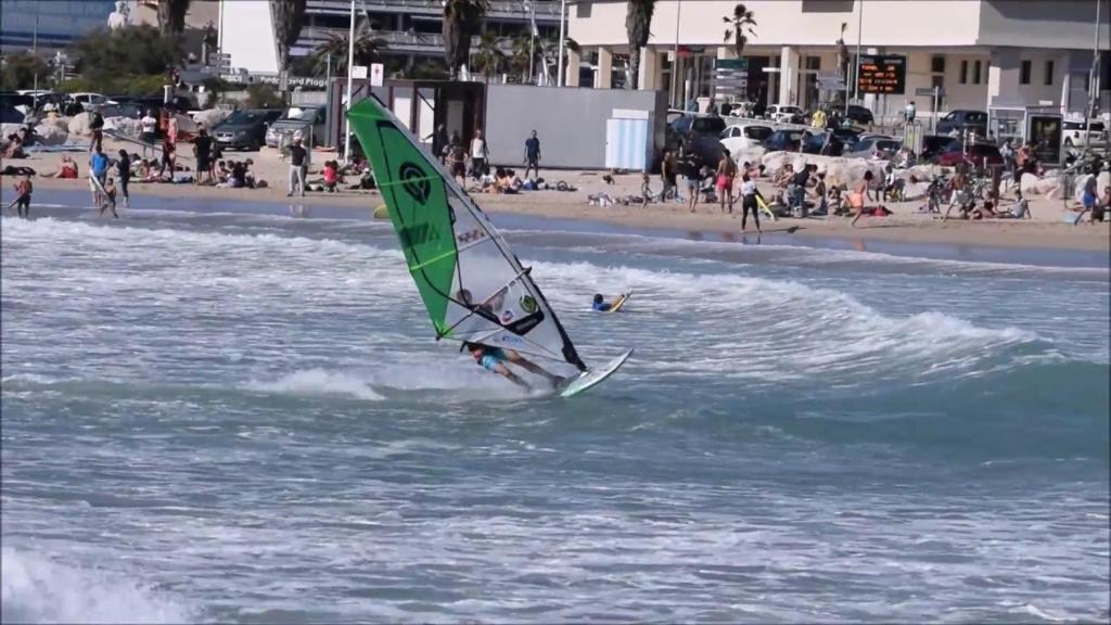a person windsurfing in the water on a beach at Cabanon du Pêcheur, Parc National des Calanques in Marseille