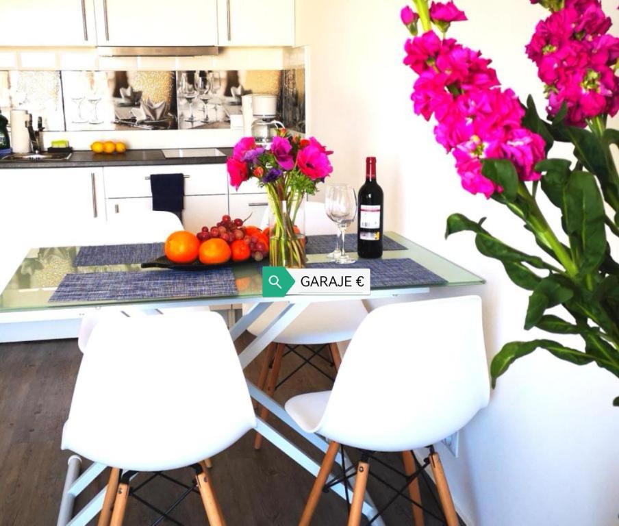 una cucina con tavolo, fiori e bottiglie di vino di Beachfront modern and spacious apartment a Torrevieja