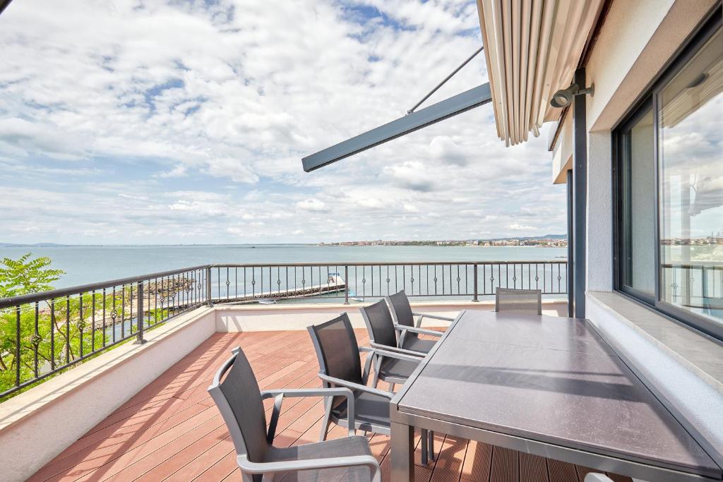 d'une salle à manger avec une table et des chaises sur un balcon. dans l'établissement 3BD Beach Paradise with a Stunning View + Parking, à Nessebar