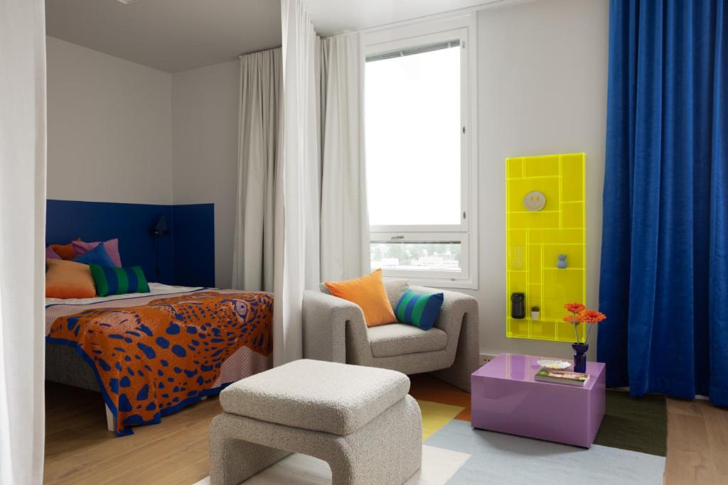 una camera con un letto e una sedia e una finestra di Noli Malmi a Helsinki