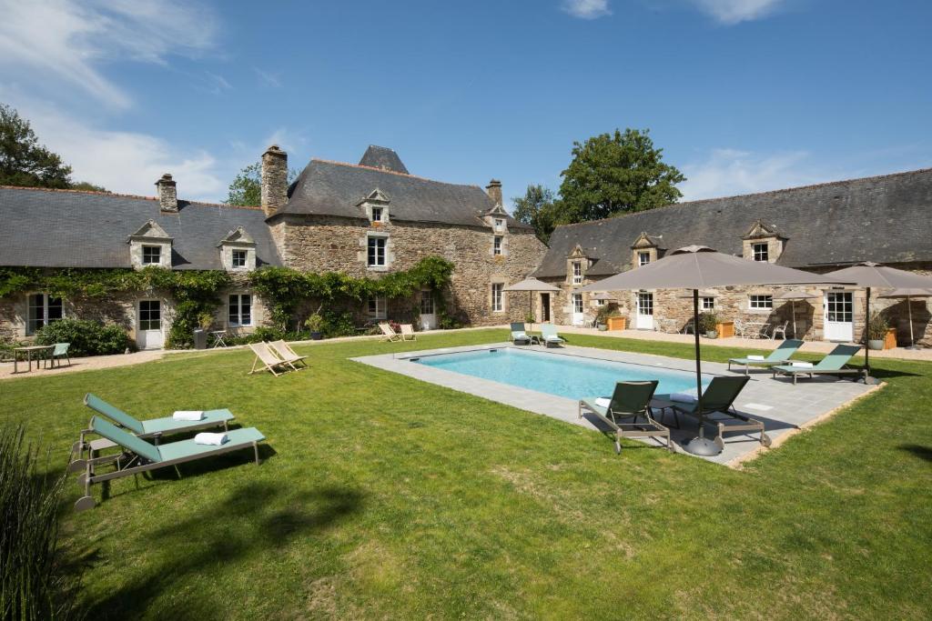 een landgoed met een zwembad en een huis bij MANOIR DU VAU D ARZ gîtes et chambres d hôtes avec piscine in Malansac