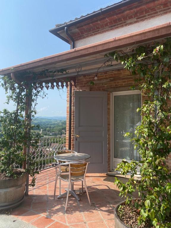 patio con tavolo e sedie di La terrazza sul Monferrato a Montegrosso dʼAsti