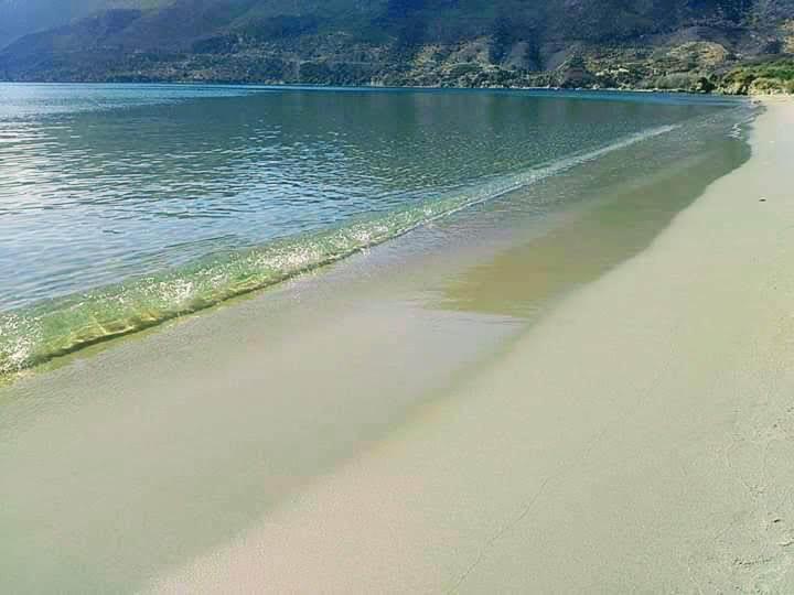 an empty beach with water and mountains in the background at NOSTALGIA HOUSE in Skoutari