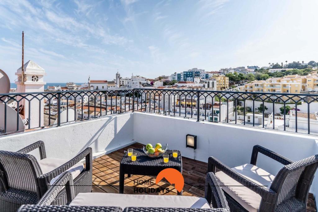 een balkon met stoelen en een tafel op een dak bij #164 Rooftop Old Town Ocean and City View, AC in Albufeira
