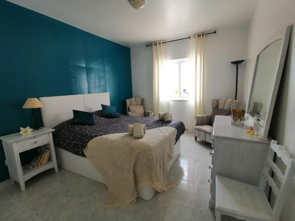 a bedroom with a bed and a chair in it at Sao Rafael Beach Flat in Albufeira