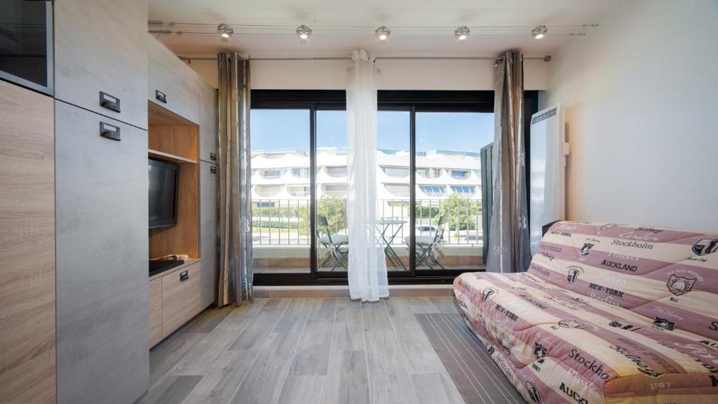 Zimmer mit einem Bett und einem großen Fenster in der Unterkunft Terrasses de l Espiguette 320 - Studio 2 pers in Le Grau-du-Roi