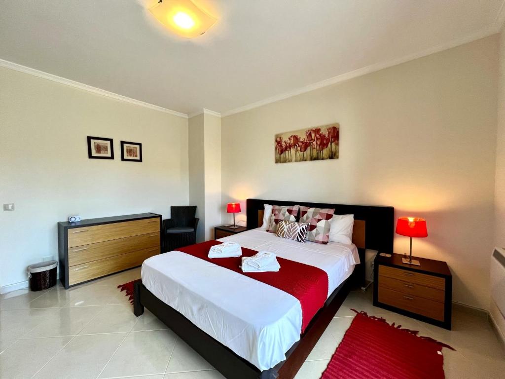 um quarto com uma cama grande e um tapete vermelho em Pêra Brightness Villa by Homing em Pêra