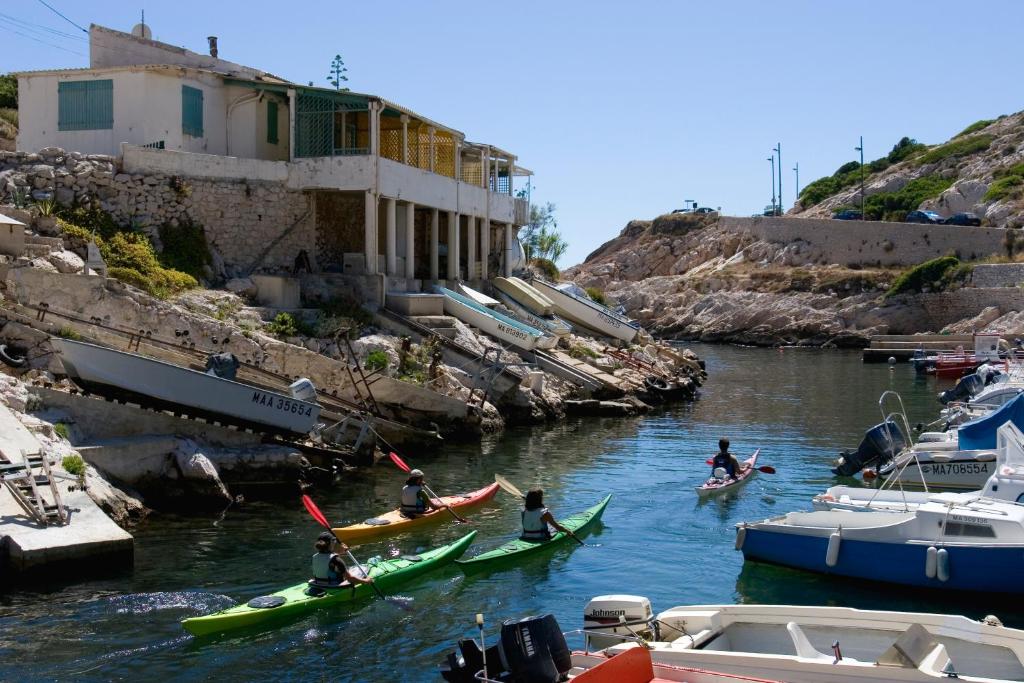 a group of people in kayaks in a river with boats at Cabanon du Pêcheur, Parc National des Calanques in Marseille