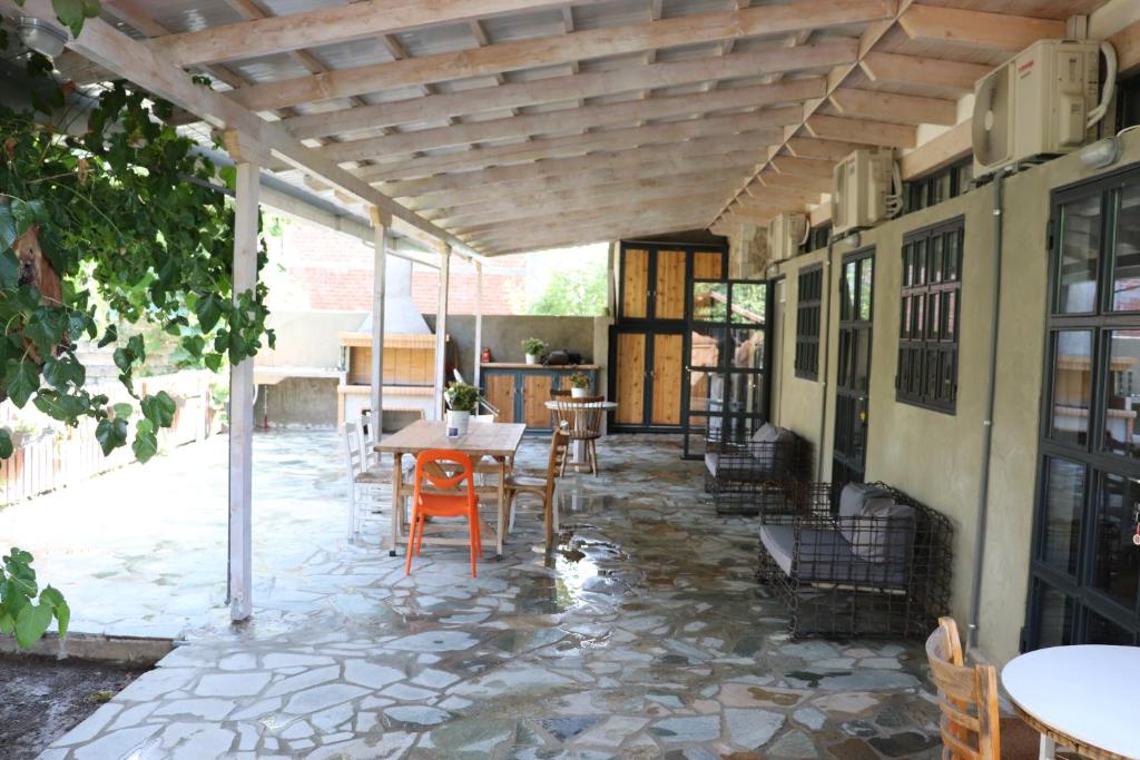 un patio con mesa y sillas bajo una pérgola en FARMAHOUSE, en Orchomenós