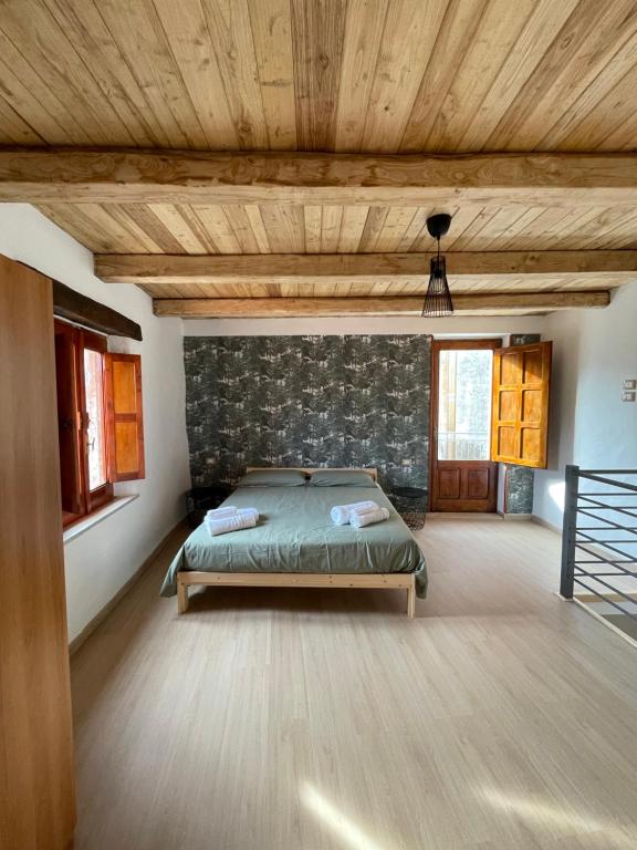 1 dormitorio con cama y techo de madera en AngeLina al borgo, en Aieta
