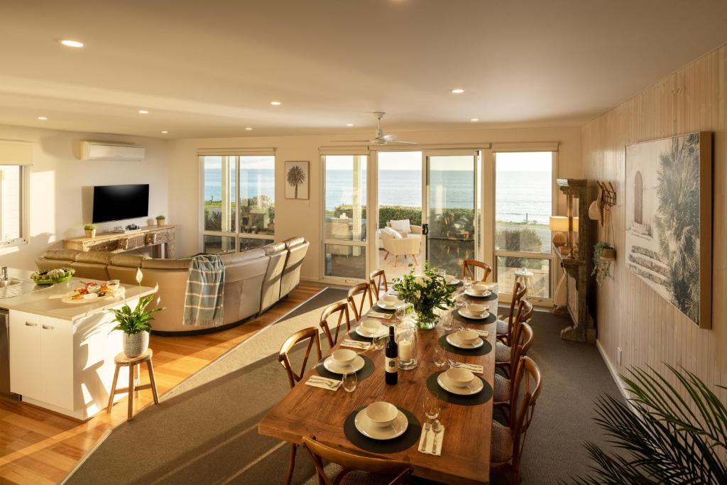 a dining room with a long table and chairs at Sol Living Beach House in Brentwood