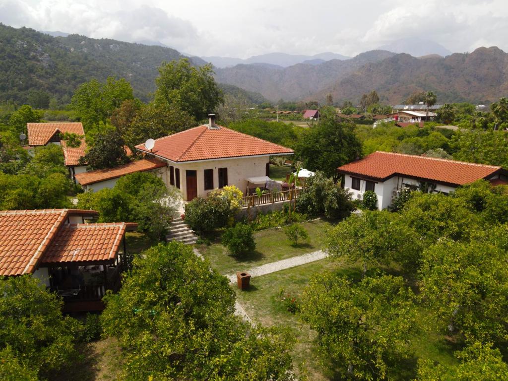 una vista aérea de una casa con montañas en el fondo en Kimera - Akdeniz Bahcesi Apart Hotel, en Cıralı